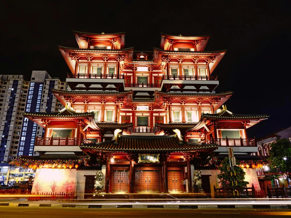 Buddha Tooth Relic Temple in Chinatown Singapore illuminated at night with traditional architecture and city surroundings